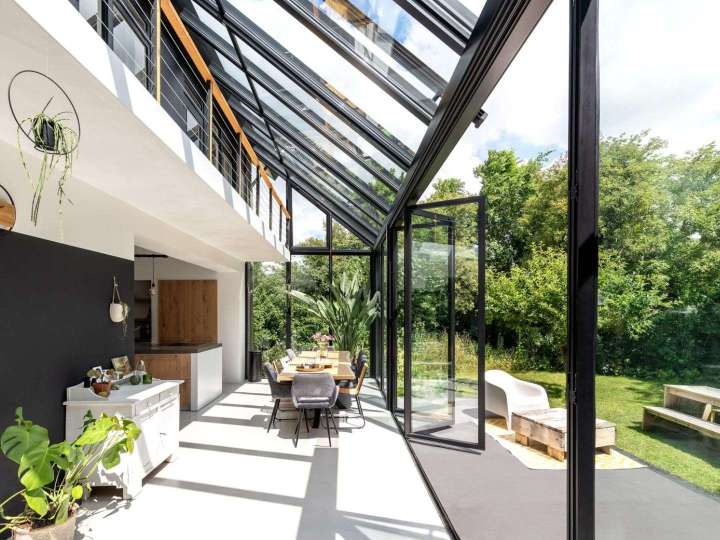 Solarlux Wintergarten SDL Akzent Plus Ecoline mit geöffneter Glasfaltwand zum Garten hin